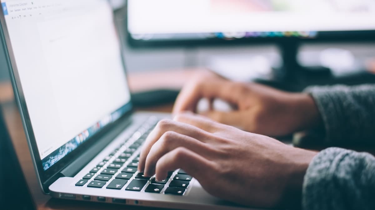 Gründer prüft am Laptop, ob er einen fremden Markennamen verwenden darf