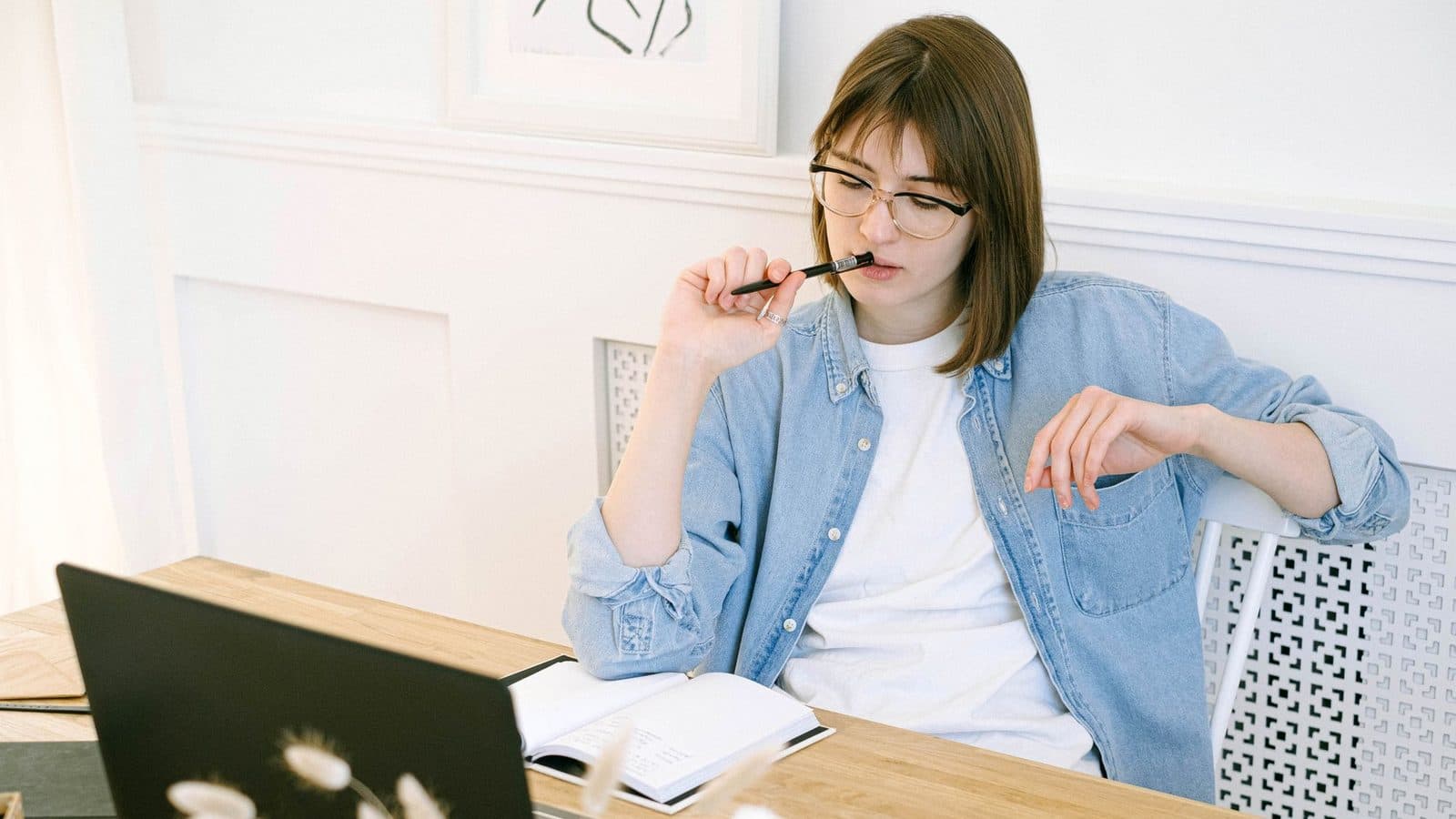 Gründerin prüft am Laptop den Status ihrer Marke, bevor sie ein Markensymbol verwendet